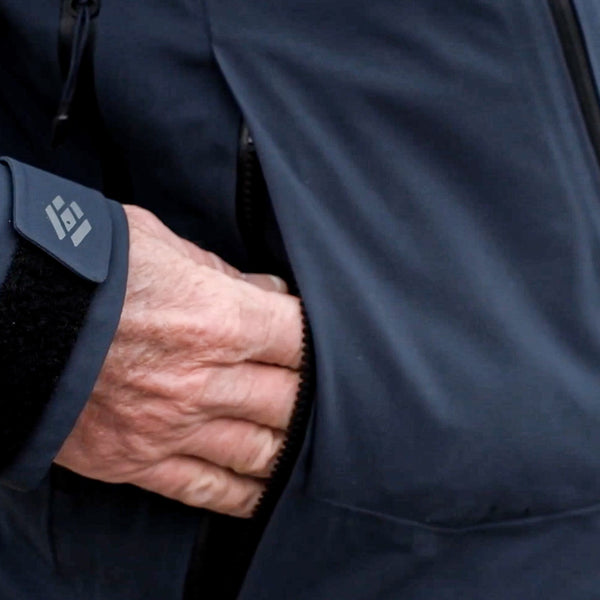 In field image of hand placed in zippered mid-body pocket. 